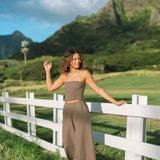Woman wearing smocked tube top and loose pant in medium brown linen.