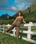 Woman wearing smocked tube top and pant in medium brown linen.