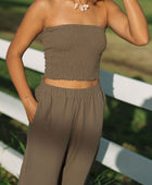 Woman wearing smocked tube top and pant in medium brown linen.