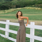 Woman wearing smocked tube top and pant in medium brown linen.