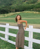 Woman wearing smocked tube top and pant in medium brown linen.