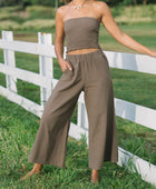 Woman wearing smocked tube top and loose pant in medium brown linen.