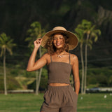 Woman wearing smocked tube top with spaghetti straps and short in medium brown linen.