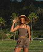 Woman wearing smocked tube top with spaghetti straps and short in medium brown linen.