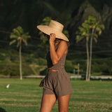 Woman wearing smocked tube top with spaghetti straps and short in medium brown linen.