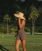 Woman wearing smocked tube top with spaghetti straps and short in medium brown linen.