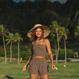 Woman wearing smocked tube top with spaghetti straps and short in medium brown linen.