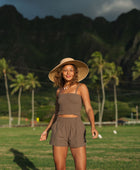 Woman wearing smocked tube top with spaghetti straps and short in medium brown linen.