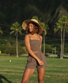 Woman wearing smocked tube top with spaghetti straps and short in medium brown linen.