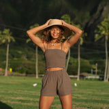 Woman wearing smocked tube top with spaghetti straps and short in medium brown linen.