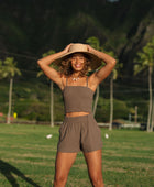 Woman wearing smocked tube top with spaghetti straps and short in medium brown linen.