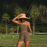 Woman wearing smocked tube top with spaghetti straps and short in medium brown linen.