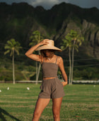 Woman wearing smocked tube top with spaghetti straps and short in medium brown linen.