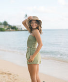 Woman wearing smocked tube top with spaghetti straps and short in medium green linen.