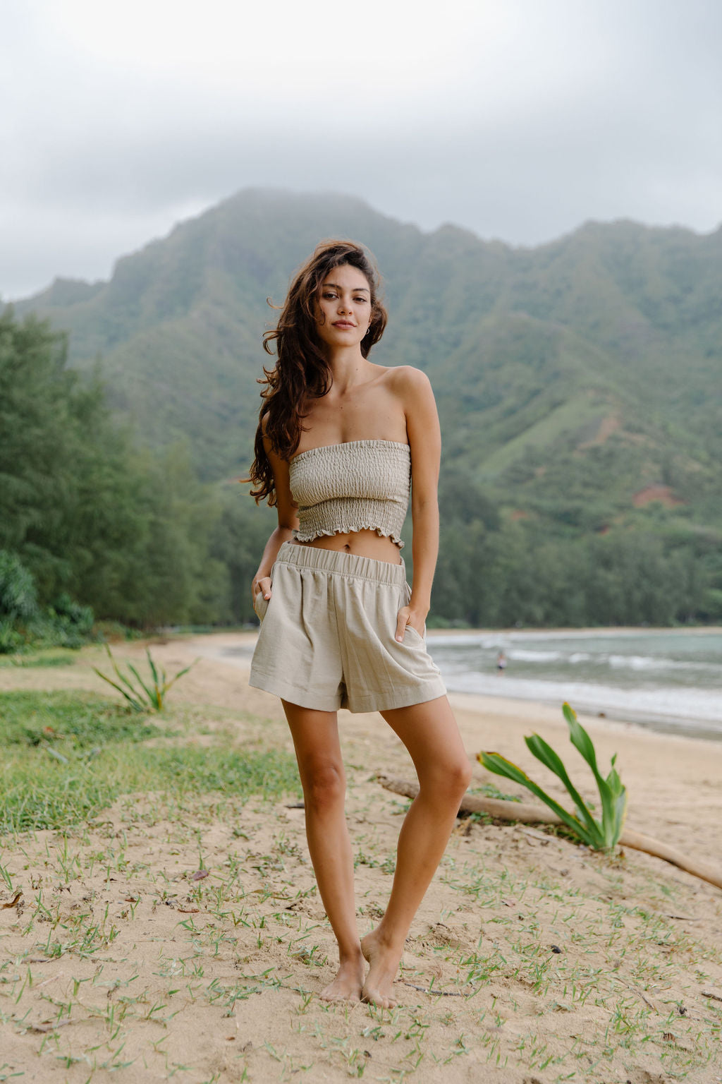 Woman wearing smocked beige linen tube top and short.