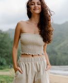 Woman wearing smocked beige linen tube top and short.