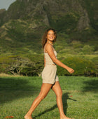 Woman wearing smocked beige linen tube top with spaghetti straps and short.