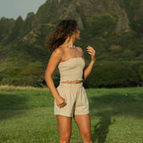 Woman wearing smocked beige linen tube top with short.