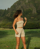 Woman wearing smocked beige linen tube top with short.