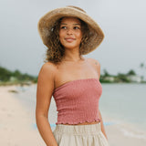 Woman wearing rose linen smocked tube top.