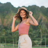 Woman wearing rose linen smocked tube top with spaghetti straps.