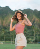 Woman wearing rose linen smocked tube top with spaghetti straps.