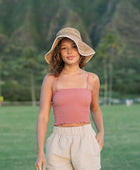 Woman wearing rose linen smocked tube top with spaghetti straps.