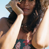 woman with brown hair wearing a teal bandeau top with removable straps with shell and pua print