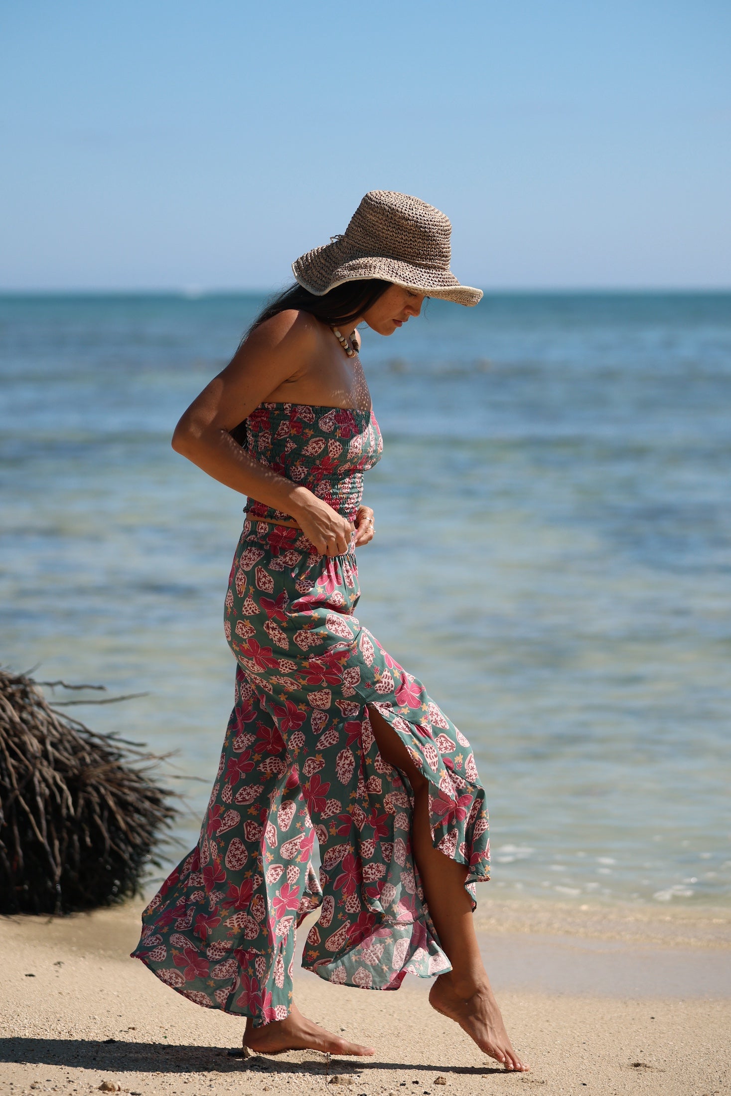 woman with brown hair wearing a teal bandeau top with removable straps with shell and pua print