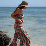 woman with brown hair wearing a teal elastic waist pant with open/slit legs in a shell and pua print