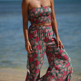 woman with brown hair wearing a teal elastic waist pant with open/slit legs in a shell and pua print