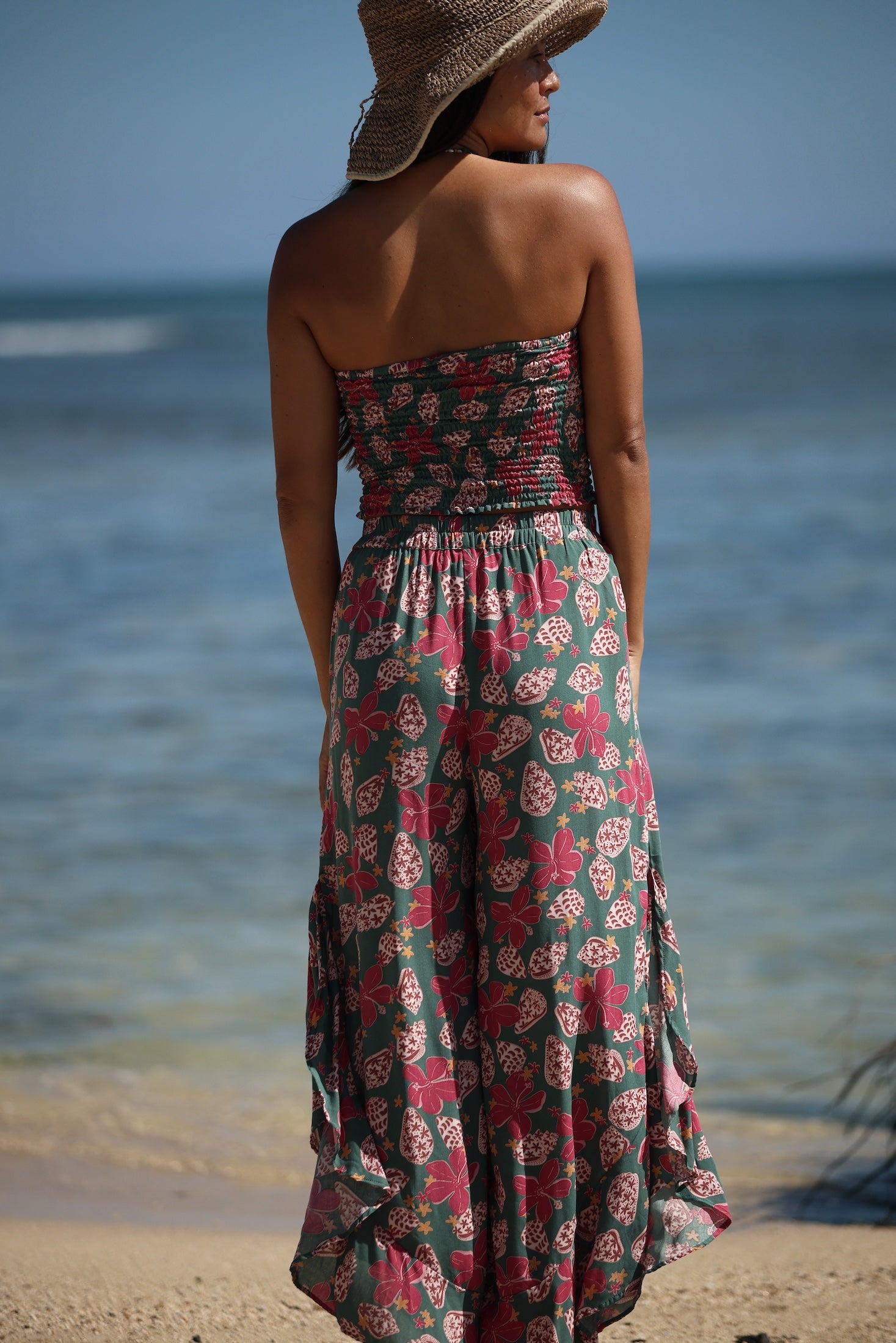 woman with brown hair wearing a teal bandeau top with removable straps with shell and pua print