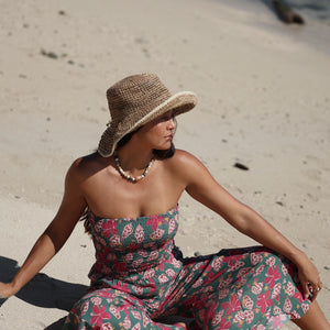 woman with brown hair wearing a teal elastic waist pant with open/slit legs in a shell and pua print