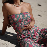 woman with brown hair wearing a teal bandeau top with removable straps with shell and pua print