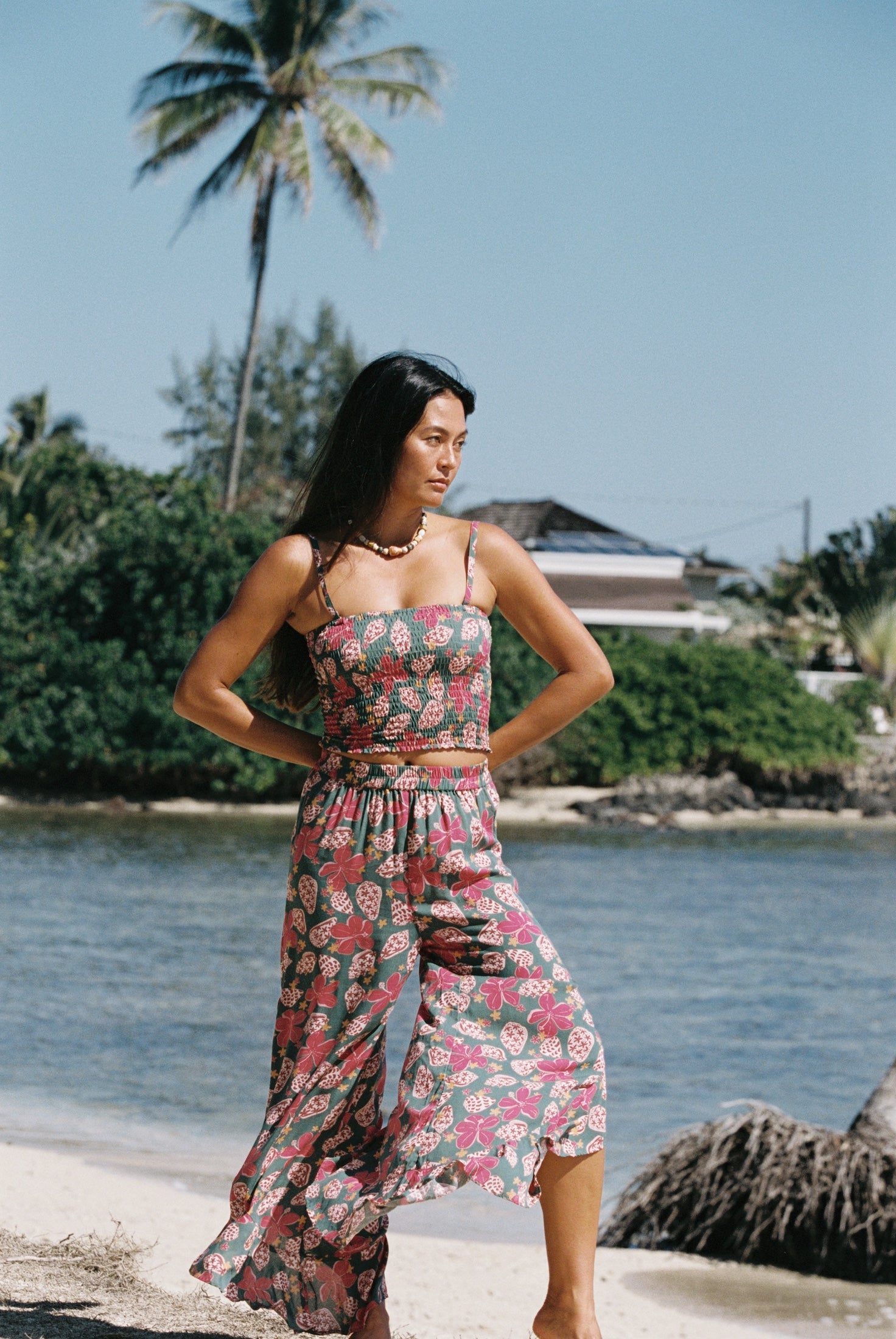 woman with brown hair wearing a teal bandeau top with removable straps with shell and pua print