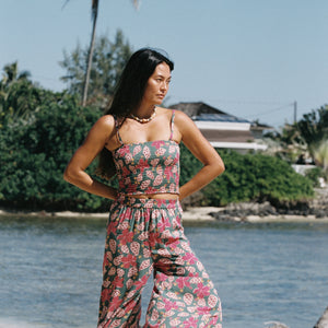 woman with brown hair wearing a teal bandeau top with removable straps with shell and pua print