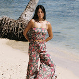 woman with brown hair wearing a teal elastic waist pant with open/slit legs in a shell and pua print