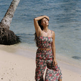 woman with brown hair wearing a teal elastic waist pant with open/slit legs in a shell and pua print