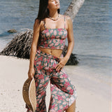 woman with brown hair wearing a teal bandeau top with removable straps with shell and pua print