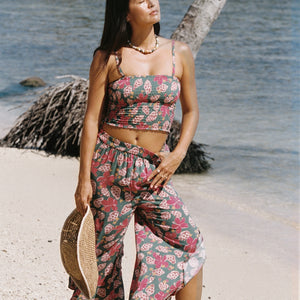 woman with brown hair wearing a teal bandeau top with removable straps with shell and pua print