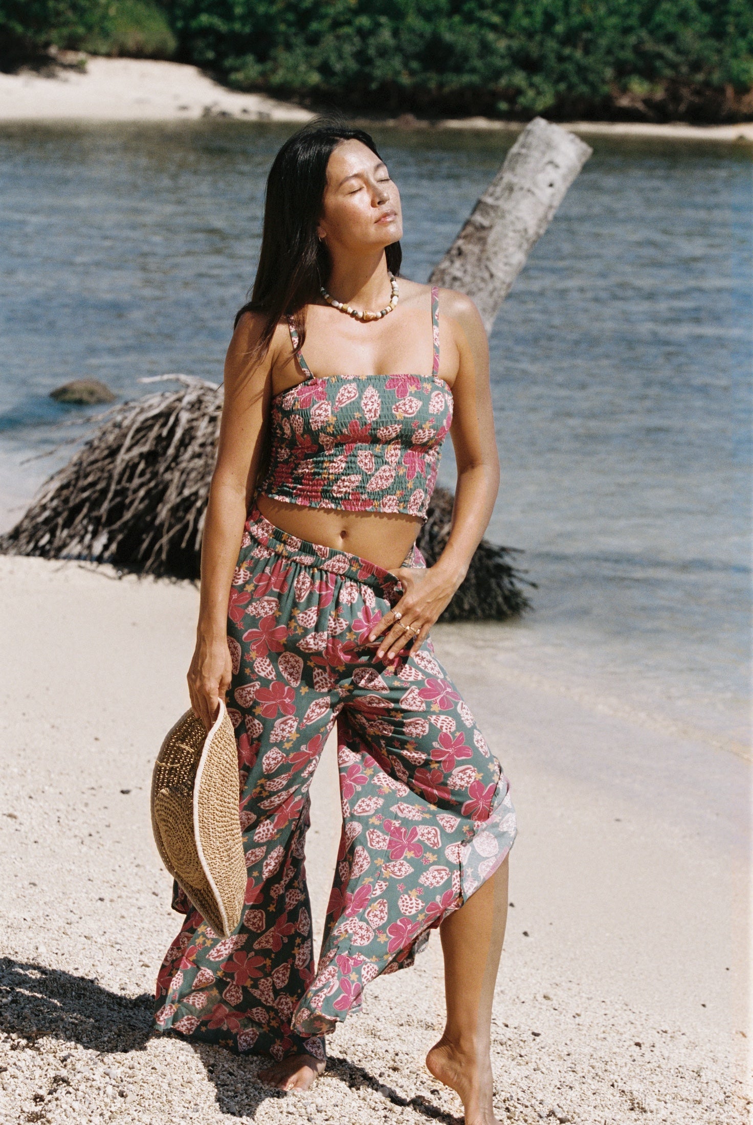 woman with brown hair wearing a teal bandeau top with removable straps with shell and pua print