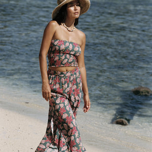 woman with brown hair wearing a teal bandeau top with removable straps with shell and pua print