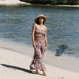 woman with brown hair wearing a teal elastic waist pant with open/slit legs in a shell and pua print
