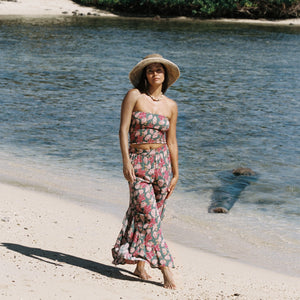woman with brown hair wearing a teal elastic waist pant with open/slit legs in a shell and pua print