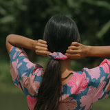 woman with black hair wearing blue and pink scrunchie with hibiscus print