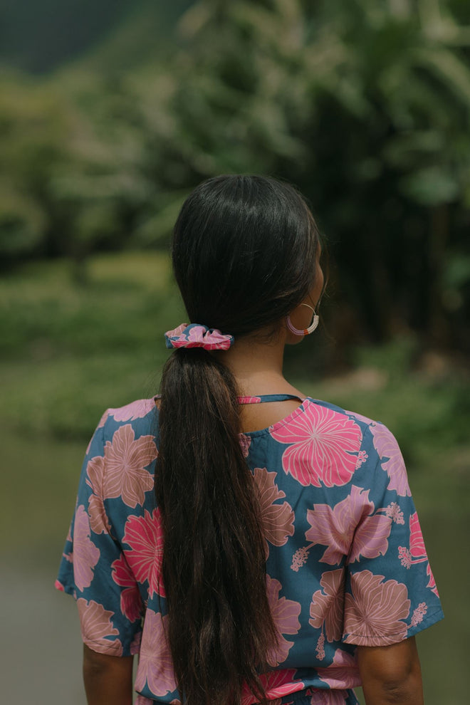 woman with black hair wearing blue and pink scrunchie with hibiscus print