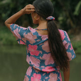 woman with black hair wearing blue and pink scrunchie with hibiscus print