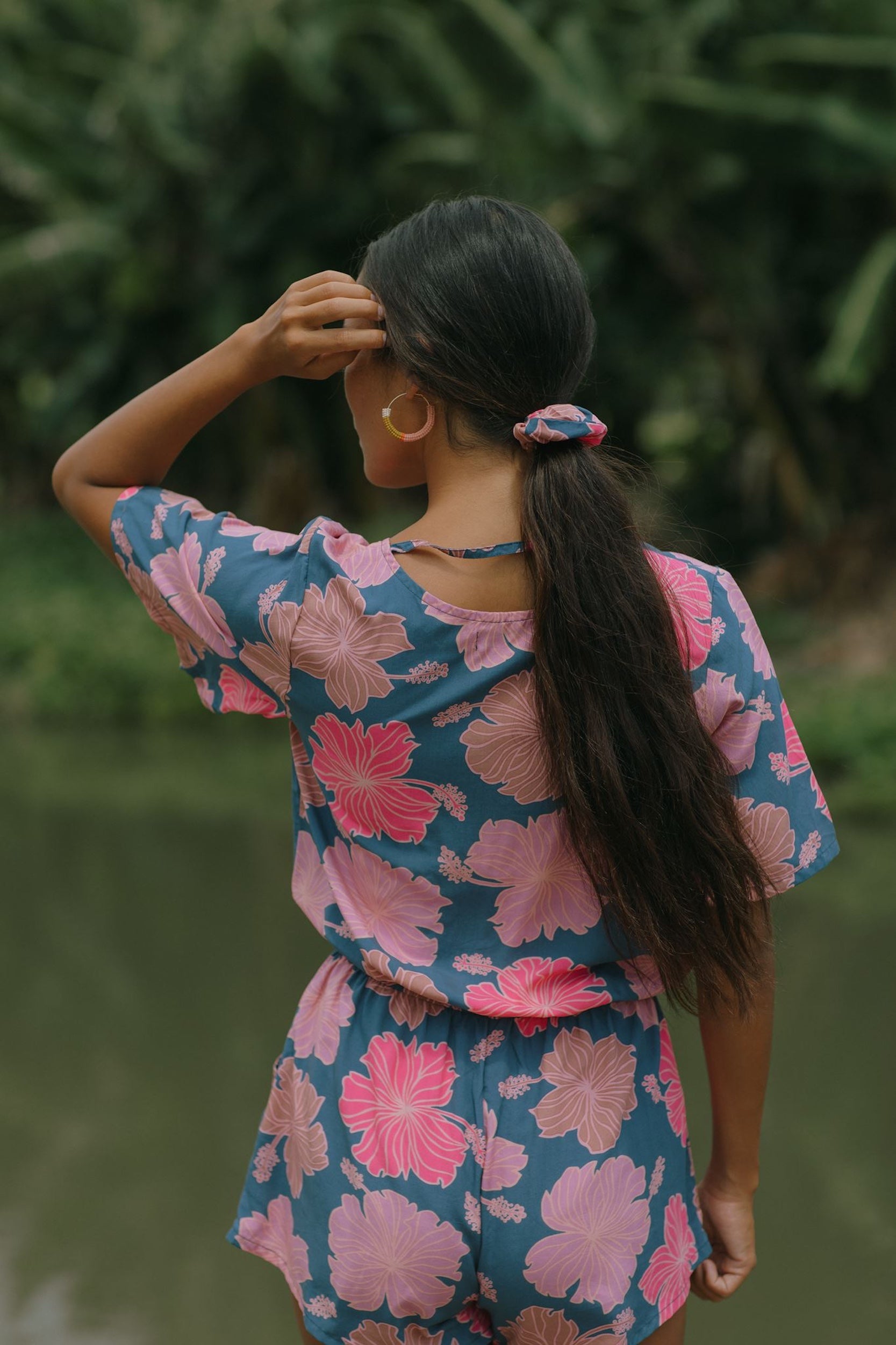 woman with black hair wearing blue and pink scrunchie with hibiscus print