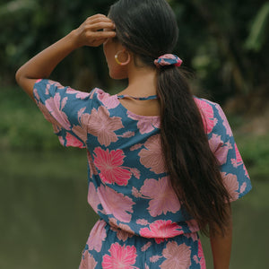 woman with black hair wearing blue and pink scrunchie with hibiscus print