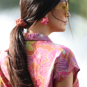 woman wearing terracotta colored scrunchie with large purple and yellow flower print